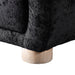 Left facing close up view of the leg on a contemporary black chenille sloping tuxedo accent armchair on a white background