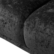 Left facing close up view of the seat on a contemporary black chenille sloping tuxedo loveseat on a white background