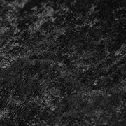 Swatch of the upholstery fabric on a contemporary black chenille sloping tuxedo loveseat