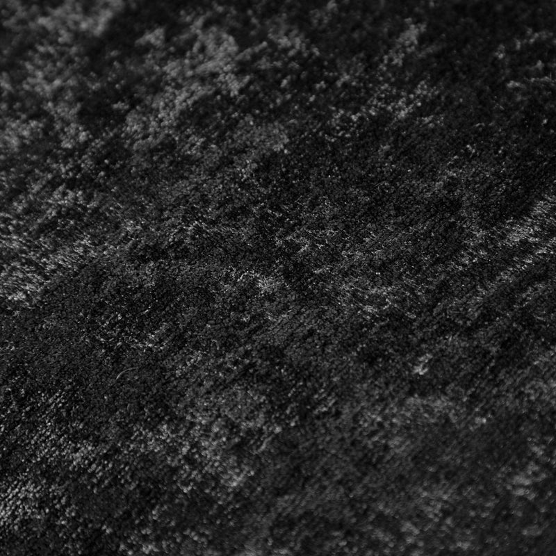 Swatch of the upholstery fabric on a contemporary black chenille sloping tuxedo loveseat