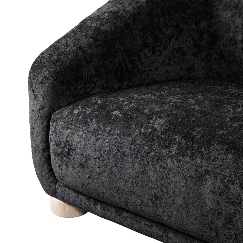 Left facing close up view of the inner armrest on a contemporary black chenille sloping tuxedo loveseat on a white background
