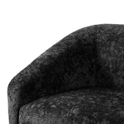 Left facing close up view of the inner armrest on a contemporary black chenille sloping tuxedo loveseat on a white background
