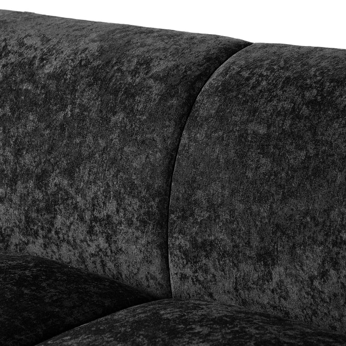 Left facing close up view of the backrest on a contemporary black chenille sloping tuxedo accent sofa on a white background
