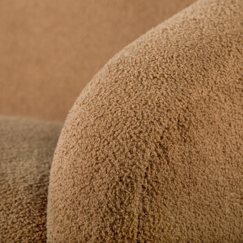 Left facing close up view of the upholstery and armrest on a contemporary brown chenille sloping tuxedo loveseat