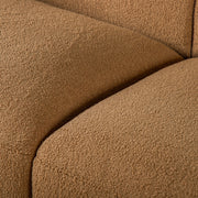 Left facing close up view of the upholstery and seat on a contemporary brown chenille sloping tuxedo loveseat