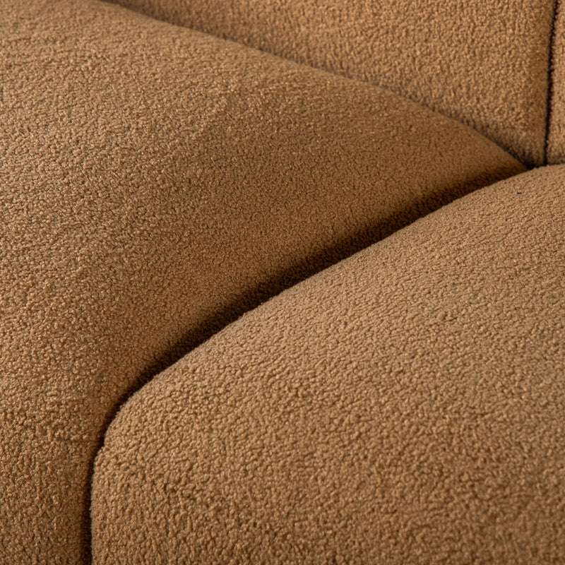 Left facing close up view of the upholstery and seat on a contemporary brown chenille sloping tuxedo loveseat