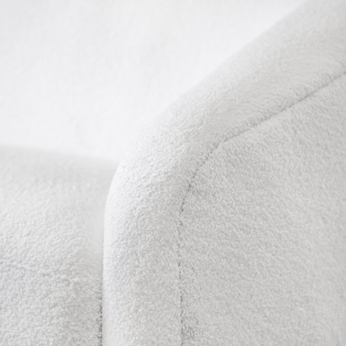 Left facing close up view of the upholstery and armrest on a contemporary white chenille sloping tuxedo accent armchair