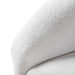 Left facing close up view of the inner armrest on a contemporary white chenille sloping tuxedo accent armchair on a white background