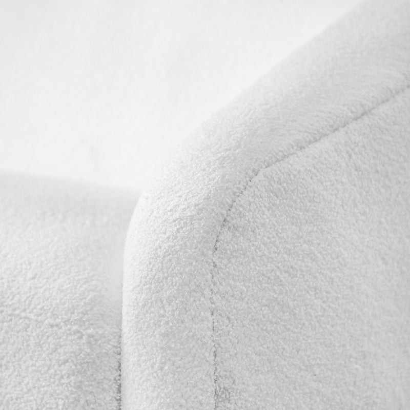 Left facing close up view of the upholstery and armrest on a contemporary white chenille sloping tuxedo loveseat