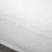 Left facing close up view of the upholstery and seat on a contemporary white chenille sloping tuxedo loveseat
