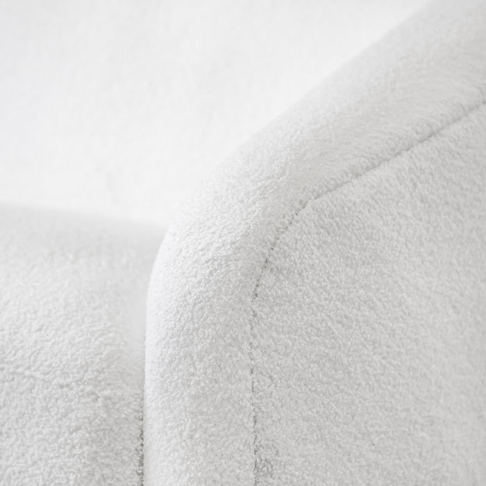 Left facing close up view of the upholstery and armrest on a contemporary white chenille sloping tuxedo sofa