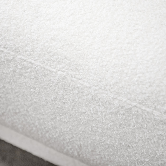 Left facing close up view of the upholstery and seat on a contemporary white chenille sloping tuxedo sofa