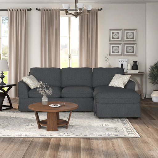 Front-facing side view transitional sectional sofa with right-facing chaise, flared arms and skirted base in a living room
