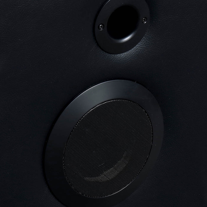 Right facing close up of speaker on a transitional black faux leather power recliner sofa with contrast stitching