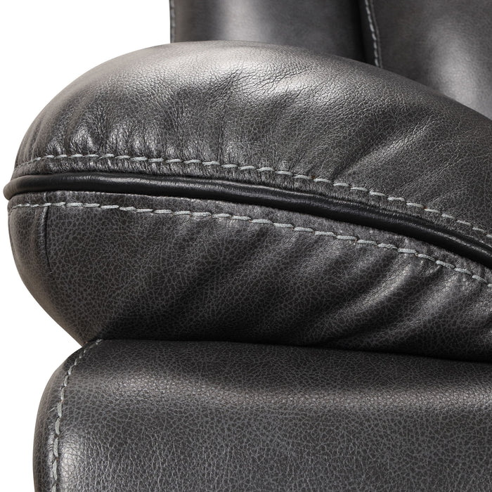 Front facing close up of the pillowtop armrest of a transitional dark grey faux leather reclining sectional sofa with a storage console