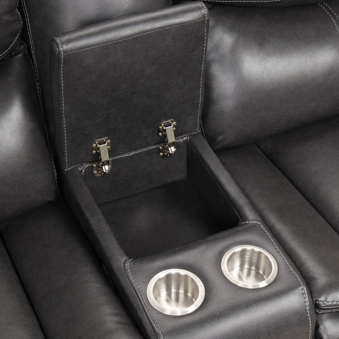 Right facing close up of the storage console and cupholders of a transitional dark grey faux leather reclining sectional sofa with a storage console