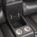 Right facing close up of the storage console and cupholders of a transitional dark grey faux leather reclining sectional sofa with a storage console