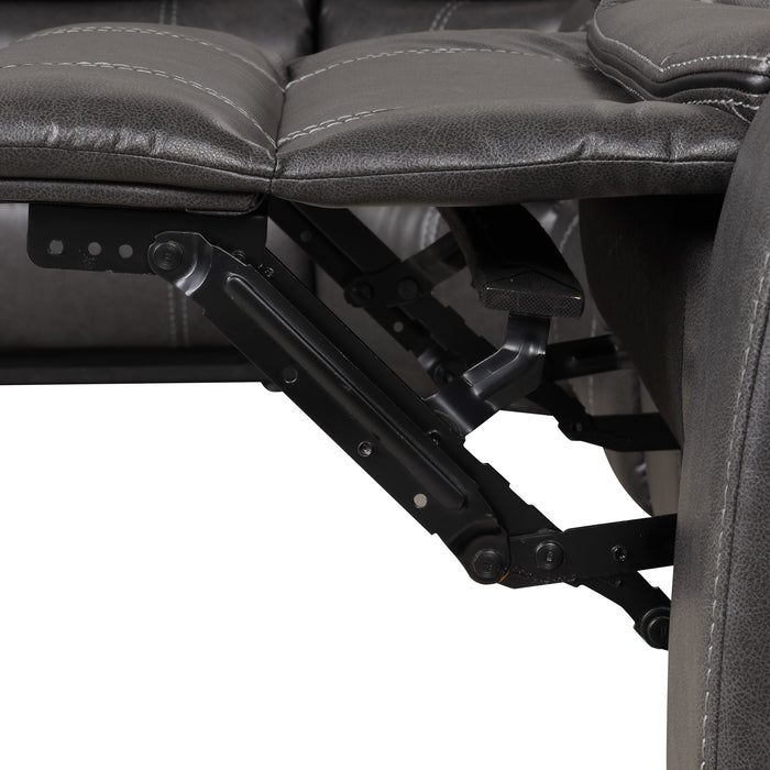 Left facing close up of the leg rest extension mechanism of a transitional dark grey faux leather reclining sectional sofa with a storage console on a white background
