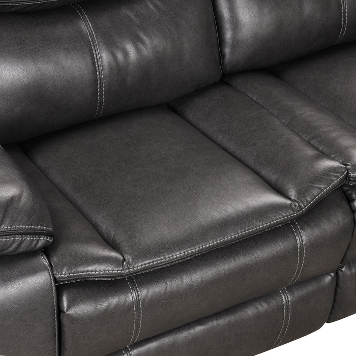 Right facing close up of the seat of a transitional dark grey faux leather reclining sectional sofa with a storage console on a white background