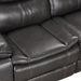 Right facing close up of the seat of a transitional dark grey faux leather reclining sectional sofa with a storage console on a white background