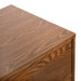 Right facing close up view of the top and corner on a mid-century modern walnut finish five-drawer chest on a white background