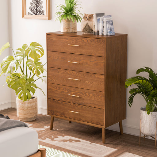 Left facing mid-century modern walnut finish five-drawer chest in a room with accessories