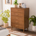 Left facing mid-century modern walnut finish five-drawer chest in a room with accessories