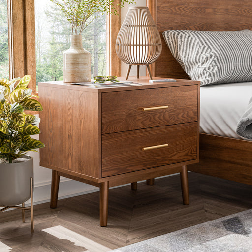 Left facing mid-century modern walnut finish two-drawer nightstand in a room with accessories