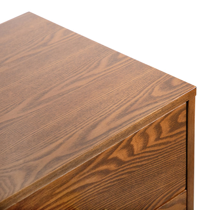 Right facing close up view of the top and corner on a mid-century modern walnut finish two-drawer nightstand on a white background