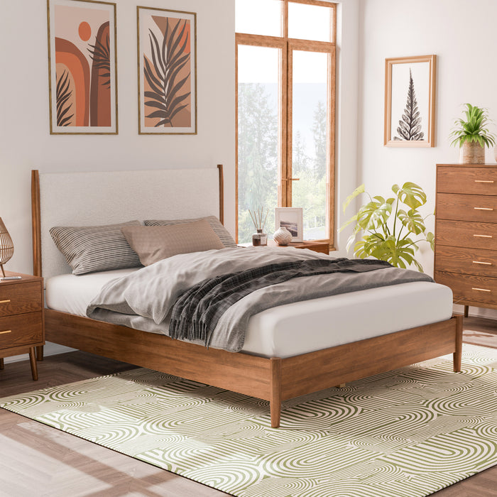 Right facing mid-century modern walnut finish and beige boucle queen bed in a room with accessories