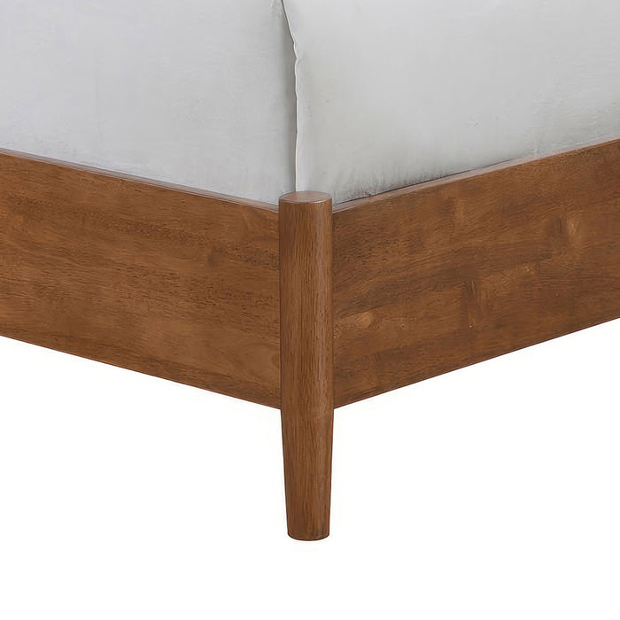 Left facing close up view of the footboard, leg, and rail on a mid-century modern walnut finish and beige boucle queen bed on a white background