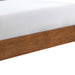 Left facing close up view of the side rail on a mid-century modern walnut finish and beige boucle queen bed on a white background
