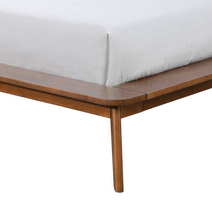 Left facing close up view of the rails and leg on a mid-century modern walnut finish rounded corner queen bed on a white background