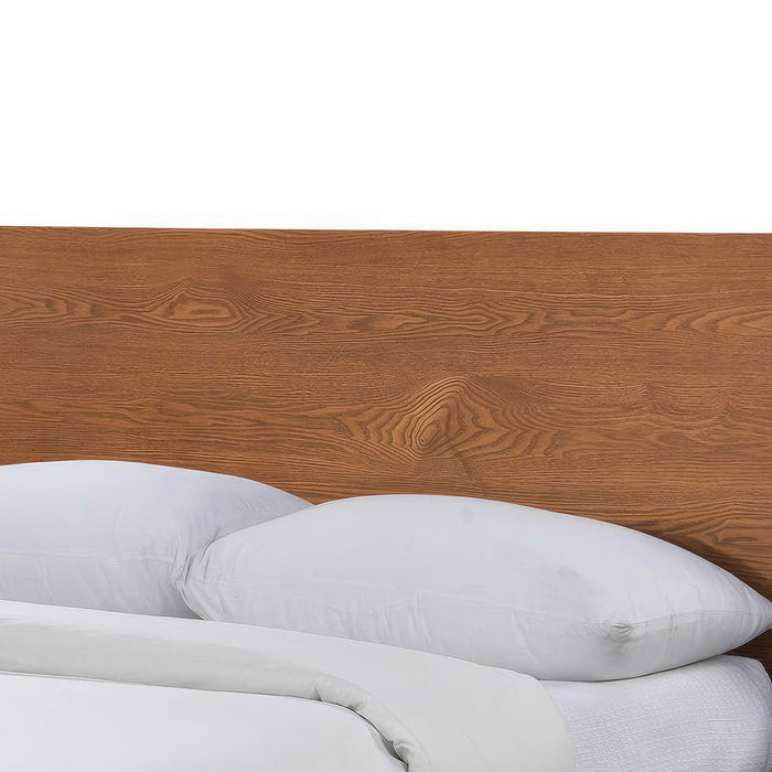 Left facing close up view of the headboard on a mid-century modern walnut finish rounded corner queen bed on a white background
