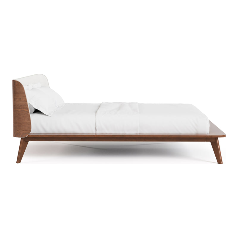 Front facing side view of a mid-century modern walnut and beige boucle wingback queen bed on a white background