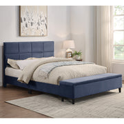 Right facing contemporary grey upholstered full bed with attached storage bench in a room with linens and accessories