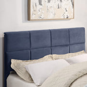 Right facing close up of the headboard on a contemporary grey upholstered full bed with attached storage bench in a room with linens and accessories