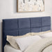 Right facing close up of the headboard on a contemporary grey upholstered full bed with attached storage bench in a room with linens and accessories