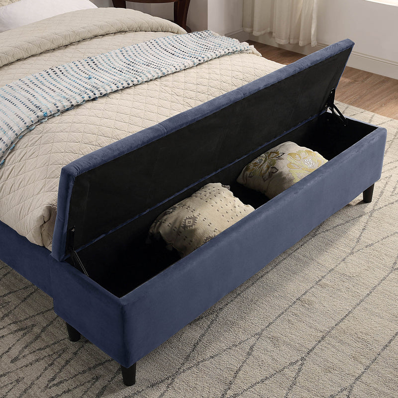 Right facing close up of the open storage bench on a contemporary grey upholstered full bed with attached storage bench in a room with linens and accessories