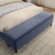 Right facing close up of the closed storage bench on a contemporary grey upholstered full bed with attached storage bench in a room with linens and accessories