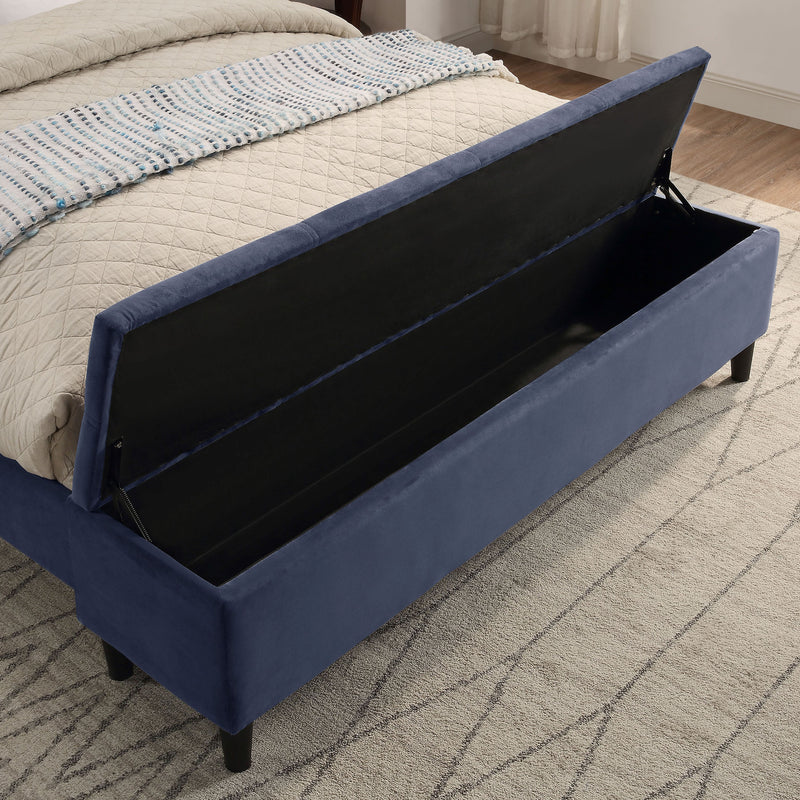 Right facing close up of the open storage bench on a contemporary grey upholstered full bed with attached storage bench in a room with linens and accessories