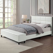 Left facing contemporary white upholstered full bed with attached storage bench in a room with linens and accessories