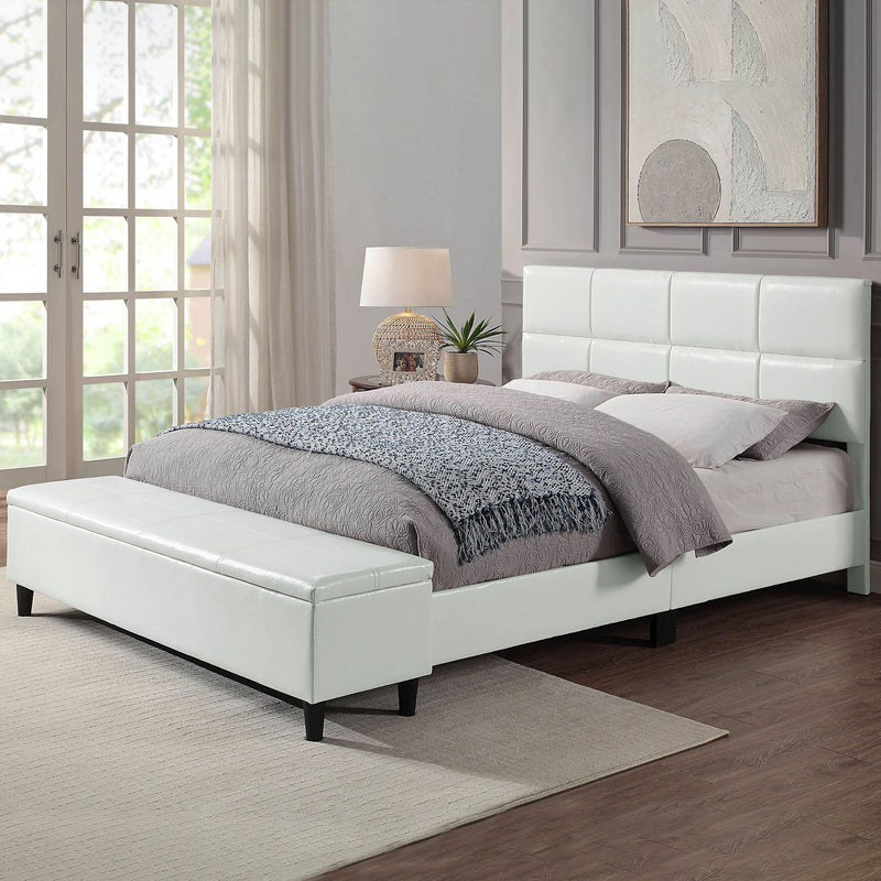 Left facing contemporary white upholstered full bed with attached storage bench in a room with linens and accessories