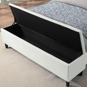 Left facing close up of the open storage bench on a contemporary white upholstered full bed with attached storage bench in a room with linens and accessories