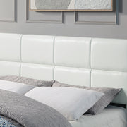 Left facing close up of the headboard on a contemporary white upholstered full bed with attached storage bench on a white background