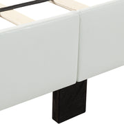 Left facing close up of the upholstered rail and wooden leg on a contemporary white upholstered full bed with attached storage bench on a white background