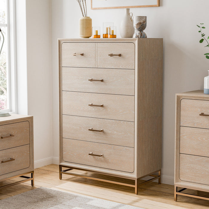 Left facing transitional light oak five-drawer chest with a metal base in a room with accessories