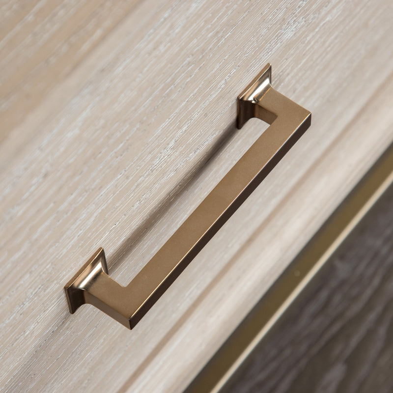 Right facing close up of the bar drawer pull on a transitional light oak eastern king platform bed with two storage drawers, on a white background