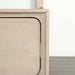 Front facing close up of the footboard drawer corner on a transitional light oak eastern king platform bed with two storage drawers, in a room