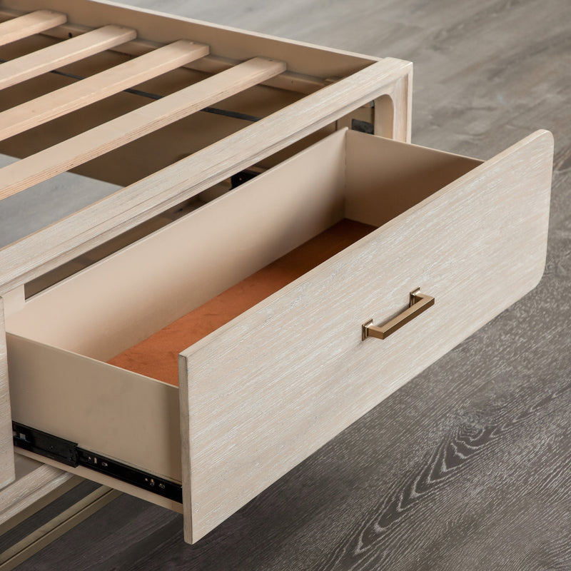 Right facing close up of an open footboard drawer on a transitional light oak eastern king platform bed with two storage drawers, in a room